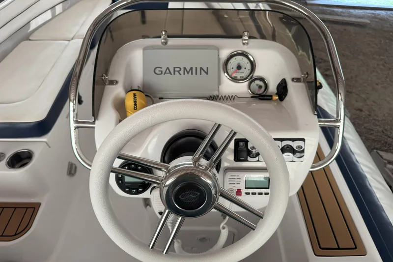 Slide: The Image of 2024 Walker Bay Generation 525 boat dashboard with Garmin navigation system and steering wheel. - 19