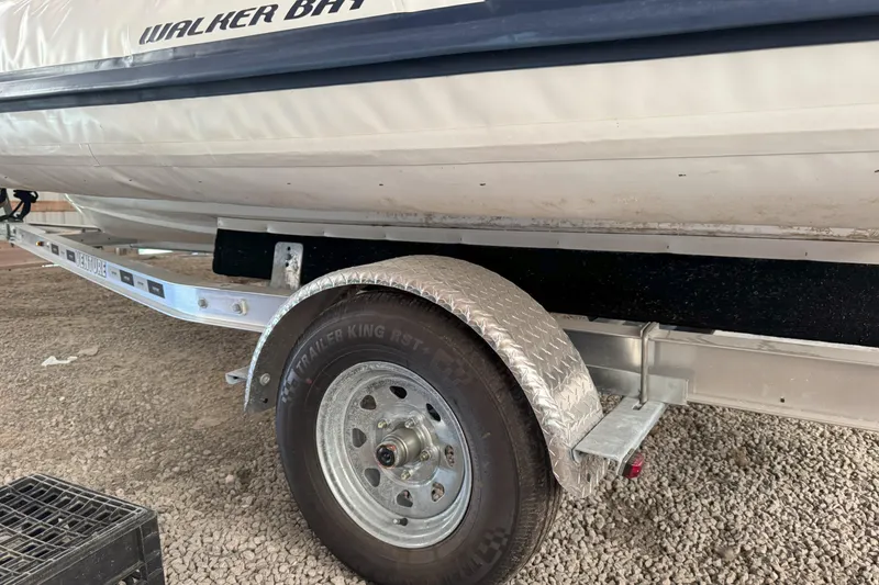 Slide: The Image of 2024 Walker Bay Generation 525 boat on a trailer, close-up of wheel and hull. - 24