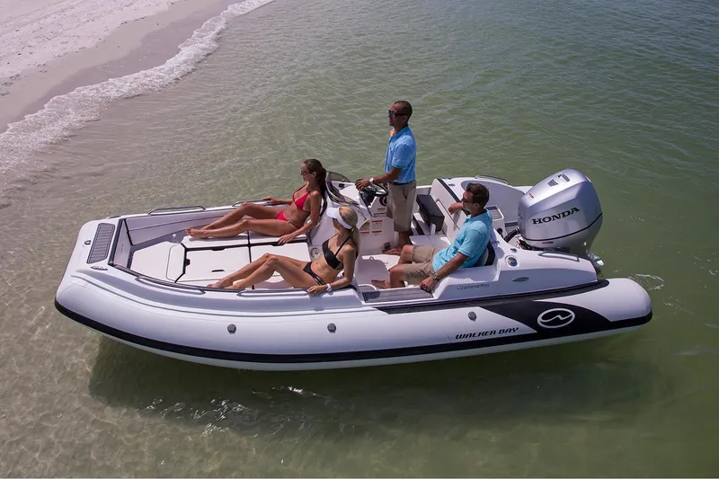 Slide: The Image of Manufacturer Provided Image: 2024 Walker Bay Generation 525 DLX boat with passengers near a sandy beach. - 3