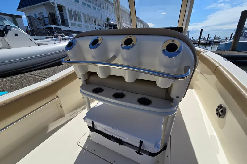 Slide: The Image of 2019 Scout 235 XSF boat interior with rod holders and seating at marina. - 12