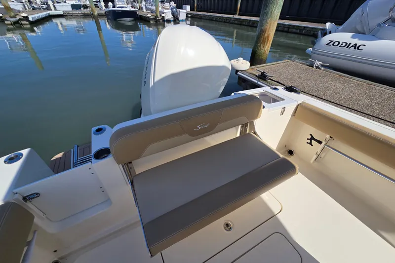Slide: The Image of 2019 Scout 235 XSF boat interior with seating and outboard motor at marina. - 13