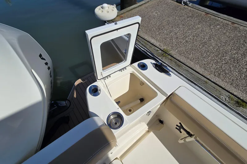 Slide: The Image of 2019 Scout 235 XSF boat with open storage compartment at dockside. - 15