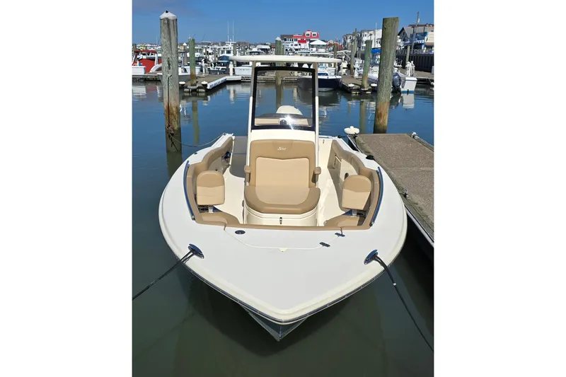 Slide: The Image of 2019 Scout 235 XSF boat docked in a marina, featuring beige seating and sleek design. - 3