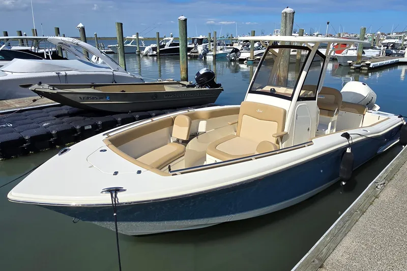 Slide: The Image of 2019 Scout 235 XSF boat docked in a marina under clear blue skies. - 4