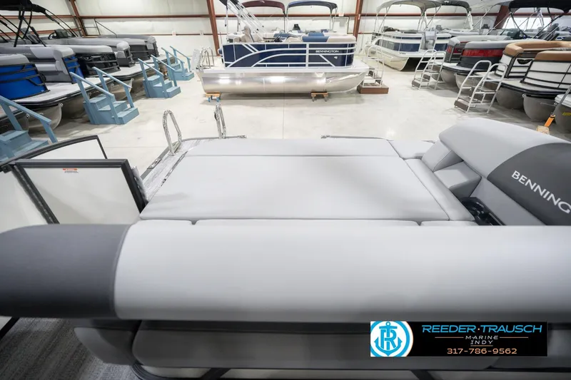 Slide: The Image of 2026 Bennington 22 SSB pontoon boat in showroom, featuring sleek design and comfortable seating. - 18