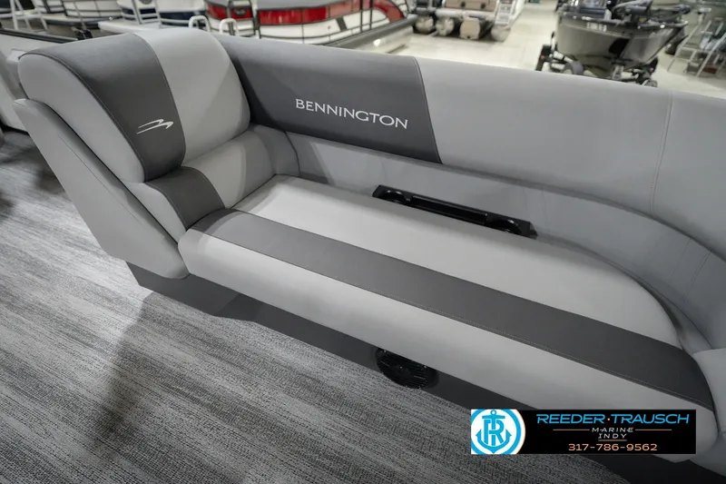 Slide: The Image of 2026 Bennington 22 SSB boat seating in showroom, featuring gray upholstery and branding. - 23