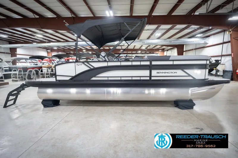 Slide: The Image of 2026 Bennington 22 SSB pontoon boat in showroom, featuring sleek design and canopy. - 7