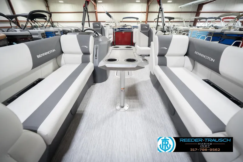 Slide: The Image of 2026 Bennington 22 SSR pontoon boat interior with gray and white seating, cup holders, and table. - 14
