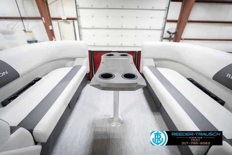 Slide: The Image of 2026 Bennington 22 SSR boat interior with seating and table, showcased in a showroom. - 19