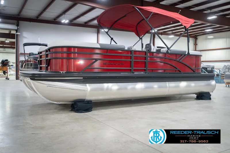 Slide: The Image of 2026 Bennington 22 SSR pontoon boat with red canopy in a showroom. - 2