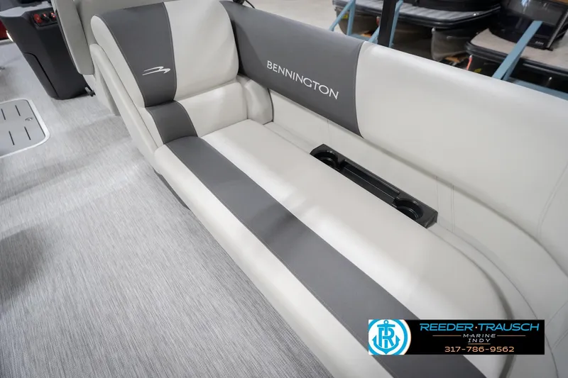 Slide: The Image of 2026 Bennington 22 SSR boat interior with gray and white seating, cup holders, and logo. - 43