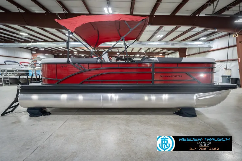 Slide: The Image of 2026 Bennington 22 SSR pontoon boat with red canopy in indoor showroom. - 5