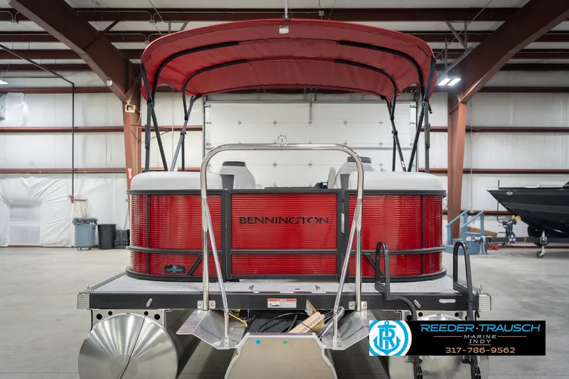 Slide: The Image of 2026 Bennington 22 SSR pontoon boat in a warehouse, featuring a red canopy and sleek design. - 7
