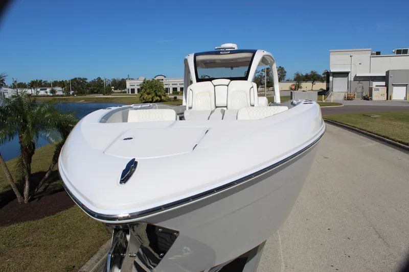 Slide: The Image of 2019 Deep Impact 399 Sport boat, sleek design, white exterior, parked outdoors. - 21
