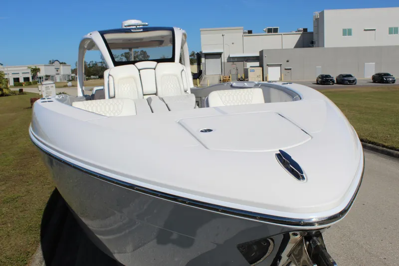 Slide: The Image of 2019 Deep Impact 399 Sport boat, sleek white design, parked outdoors. - 22