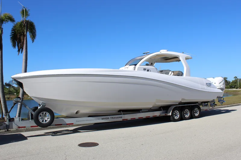 Slide: The Image of 2019 Deep Impact 399 Sport boat on trailer, parked near palm trees. - 4
