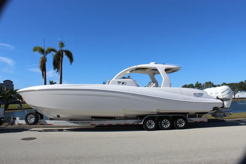 Slide: The Image of 2019 Deep Impact 399 Sport boat on trailer, parked near palm trees. - 8