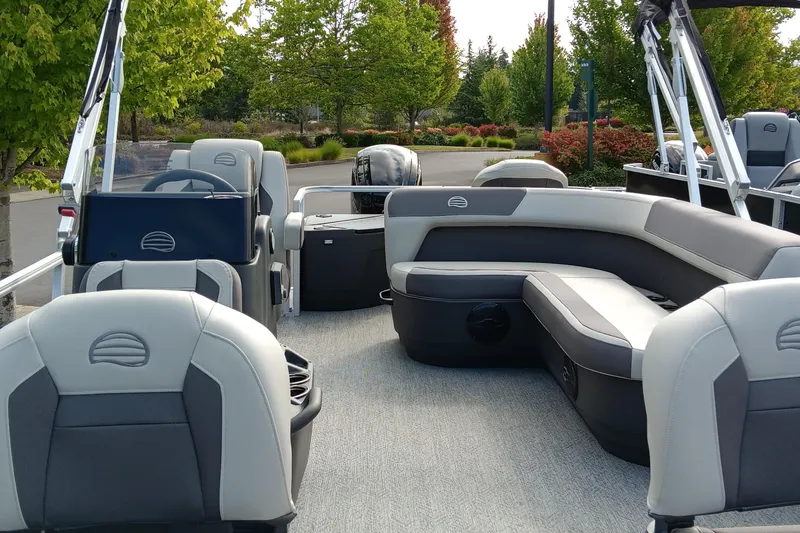 Slide: The Image of 2026 Sun Tracker Bass Buggy 18 DLX pontoon boat interior with seating and steering console. - 2