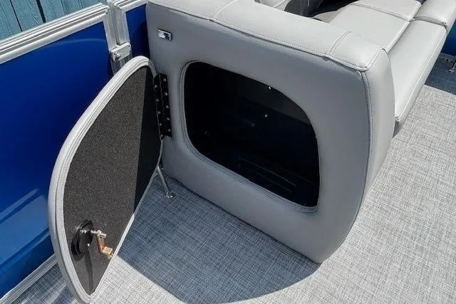 Slide: The Image of 2026 Sun Tracker Party Barge 18 DLX storage compartment with open seat and blue panel. - 13