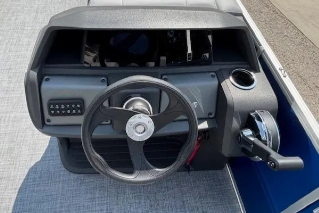 Slide: The Image of 2026 Sun Tracker Party Barge 18 DLX steering console with controls and cup holder. - 16