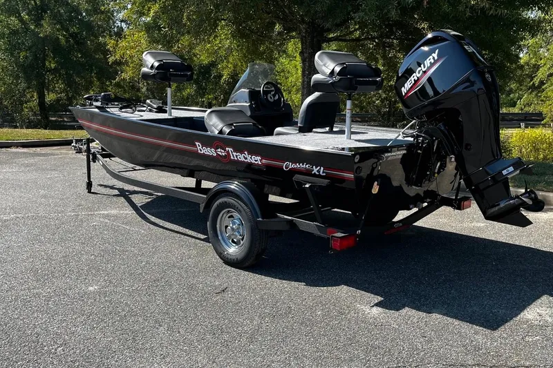 Slide: The Image of 2026 Tracker Bass Tracker Classic XL boat with Mercury engine in a sunny outdoor setting. - 3