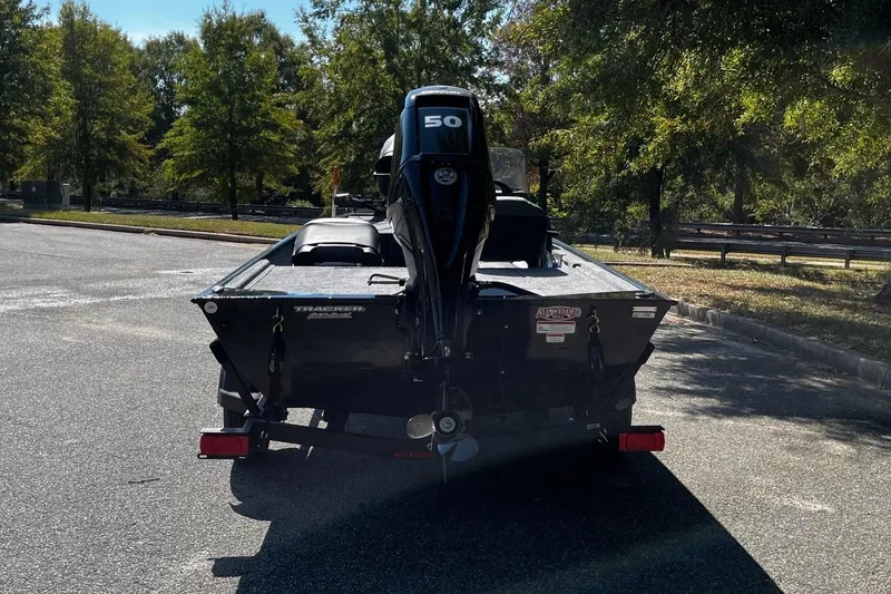 Slide: The Image of 2026 Tracker Bass Tracker Classic XL boat with 50 HP motor in a parking lot. - 4