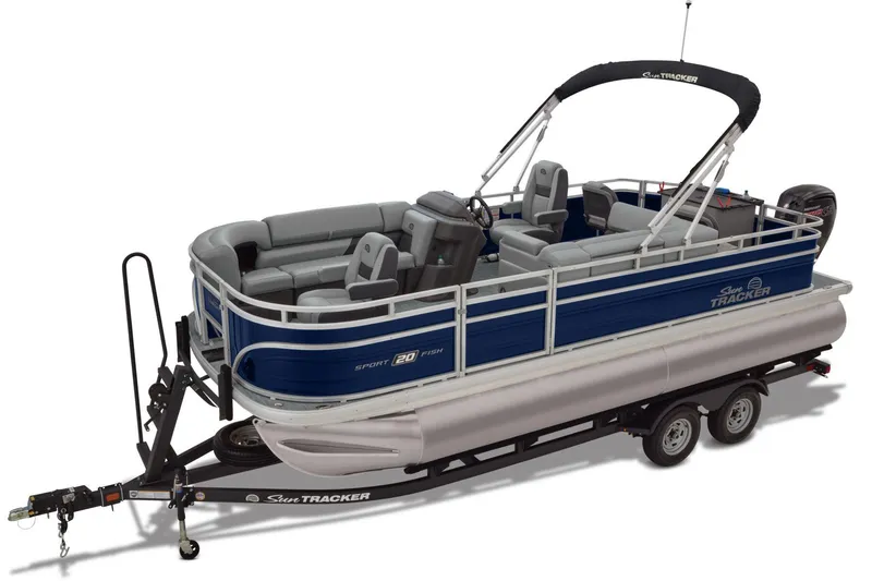 Slide: The Image of 2026 Sun Tracker SportFish 20 DLX pontoon boat with canopy, parked on trailer, scenic background. - 2