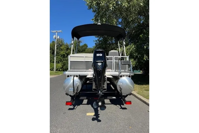 Slide: The Image of 2026 Sun Tracker Bass Buggy 16 XL Select pontoon boat with 50 HP motor, parked outdoors. - 3