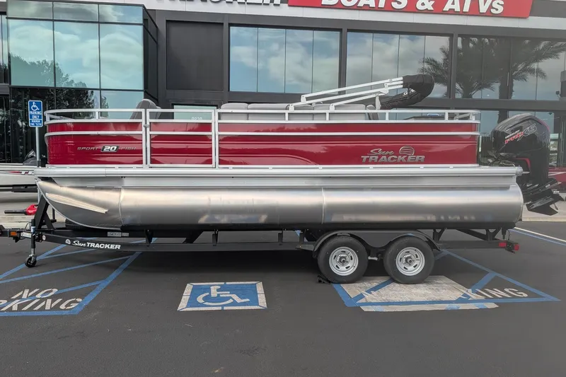 Slide: The Image of 2026 Sun Tracker SportFish 20 DLX pontoon boat on trailer, parked outside dealership. - 3