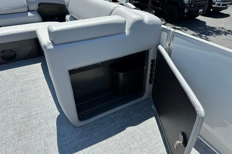 Slide: The Image of 2026 Sun Tracker Party Barge 20 DLX interior storage compartment with open door. - 25