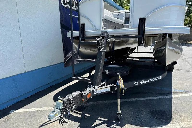 Slide: The Image of 2026 Sun Tracker Party Barge 20 DLX pontoon boat on trailer in parking lot. - 3