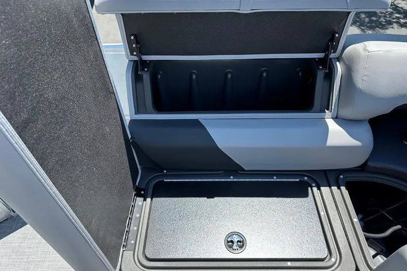 Slide: The Image of 2026 Sun Tracker Party Barge 20 DLX storage compartment with open lid, showcasing interior space. - 30