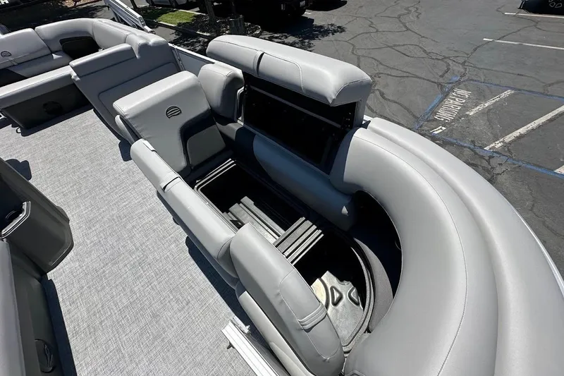 Slide: The Image of 2026 Sun Tracker Party Barge 20 DLX with open storage compartment, gray seating, and spacious deck. - 32