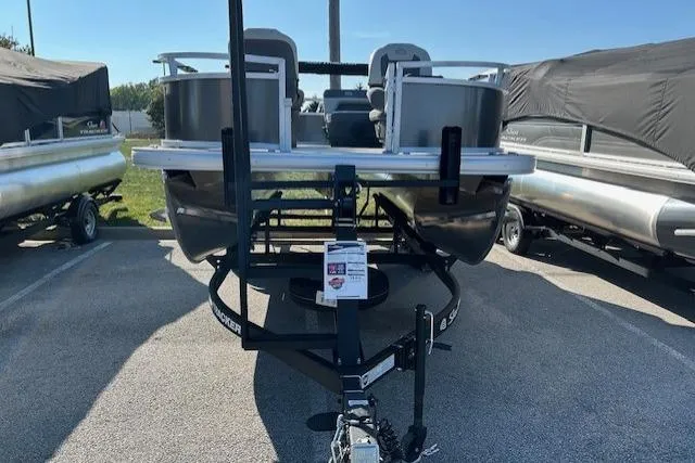 Slide: The Image of 2026 Sun Tracker Bass Buggy 16 XL Select pontoon boat on trailer in parking lot. - 2