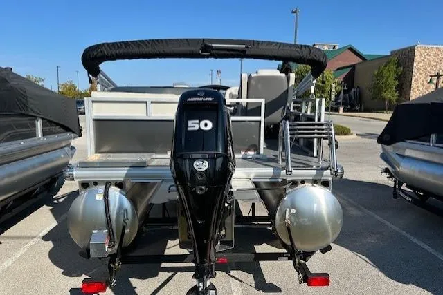 Slide: The Image of 2026 Sun Tracker Bass Buggy 16 XL Select pontoon boat with Mercury 50 engine, parked outdoors. - 3