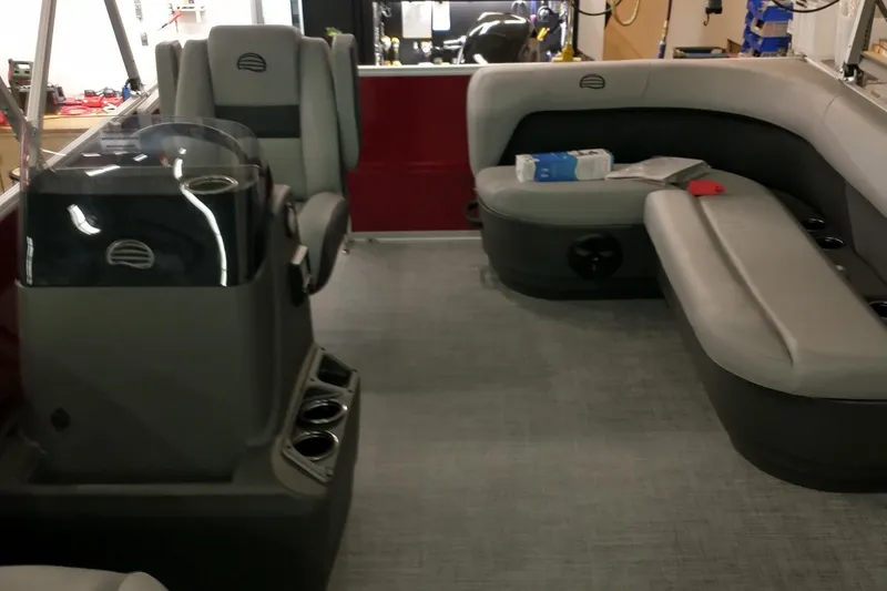 Slide: The Image of 2026 Sun Tracker Party Barge 16 DLX interior with gray seating and helm station. - 2