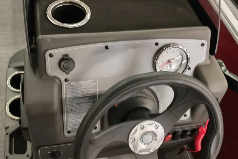 Slide: The Image of 2026 Sun Tracker Party Barge 16 DLX dashboard with steering wheel and RPM gauge. - 5