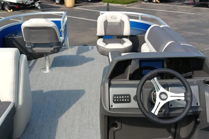 Slide: The Image of 2026 Sun Tracker Fishin' Barge 20 DLX interior with steering wheel and seating. - 2