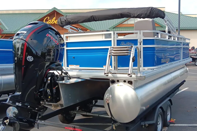 Slide: The Image of 2026 Sun Tracker Fishin' Barge 20 DLX pontoon boat with Mercury Pro motor in parking lot. - 4