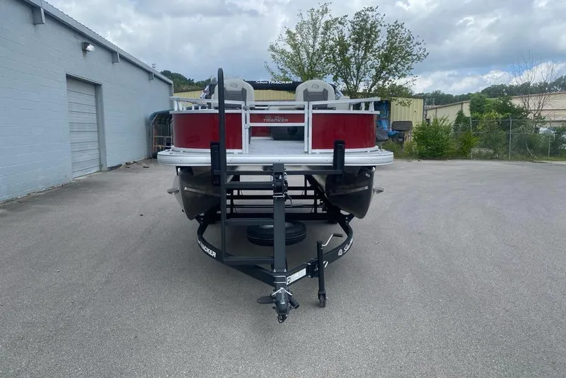 Slide: The Image of 2026 Sun Tracker Bass Buggy 16 XL Select pontoon boat on trailer, parked outdoors. - 4
