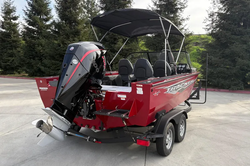 Slide: The Image of 2026 Tracker Targa V-19 Combo boat with outboard motor on trailer, parked outdoors. - 65