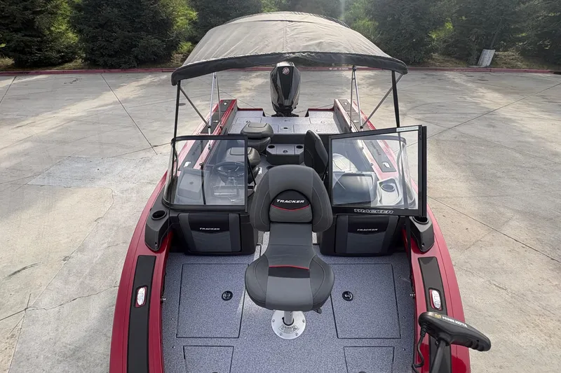 Slide: The Image of 2026 Tracker Targa V-19 Combo boat with canopy and seating, parked on concrete. - 68