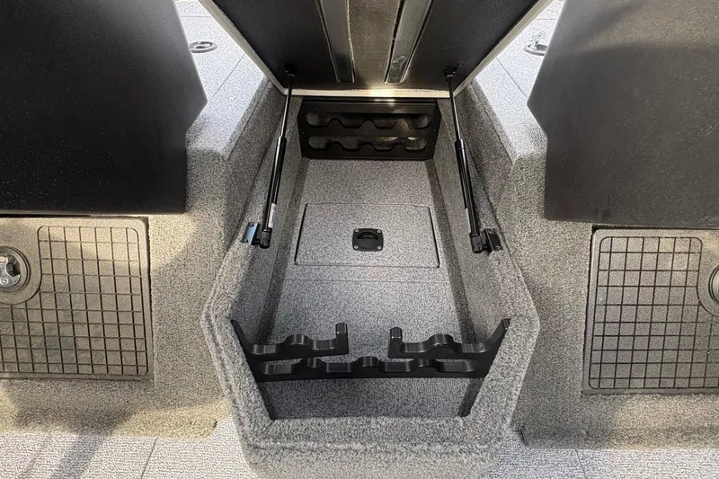 Slide: The Image of 2026 Tracker Targa V-19 Combo boat storage compartment with rod holders and carpeted interior. - 71