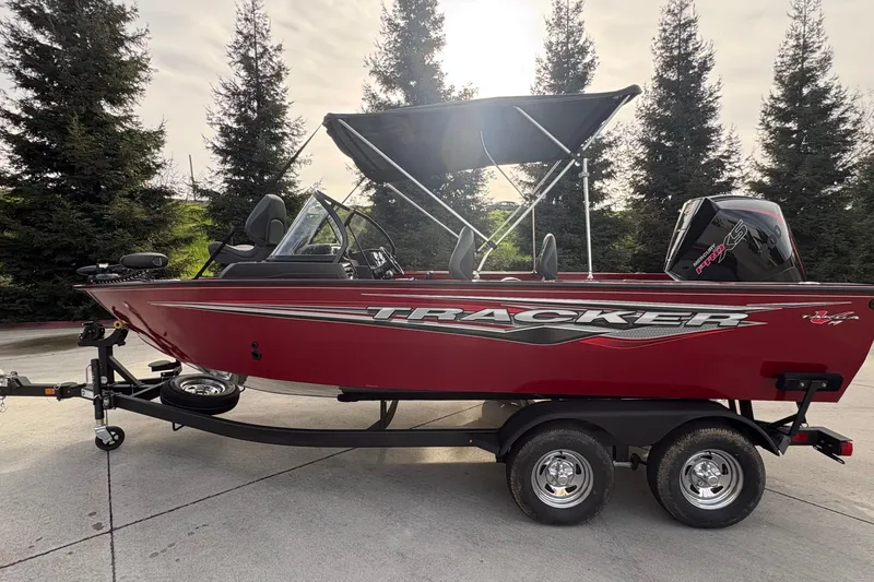 Slide: The Image of 2026 Tracker Targa V-19 Combo boat on trailer, red exterior, parked outdoors. - 82