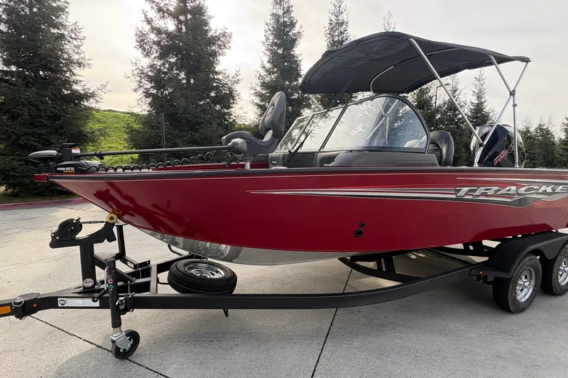 Slide: The Image of 2026 Tracker Targa V-19 Combo boat in red on trailer, parked outdoors. - 84