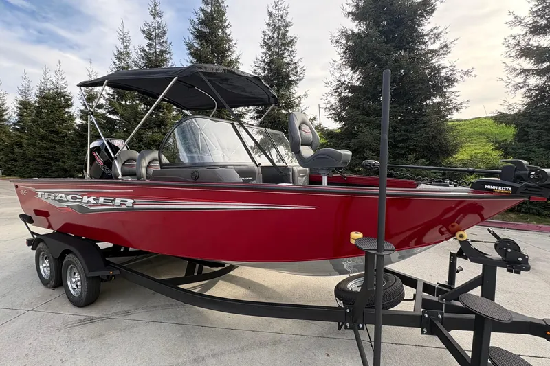 Slide: The Image of 2026 Tracker Targa V-19 Combo boat in red on trailer, parked outdoors. - 87