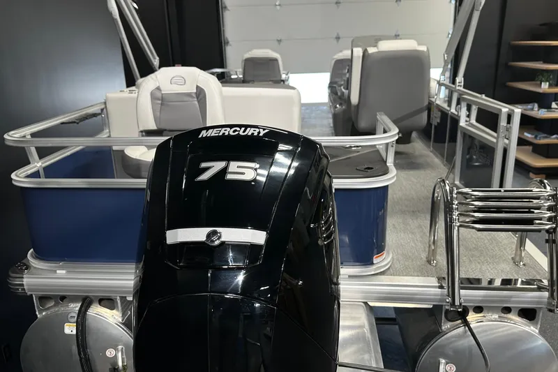 Slide: The Image of 2026 Sun Tracker Bass Buggy 18 DLX with Mercury 75 engine in showroom. - 18