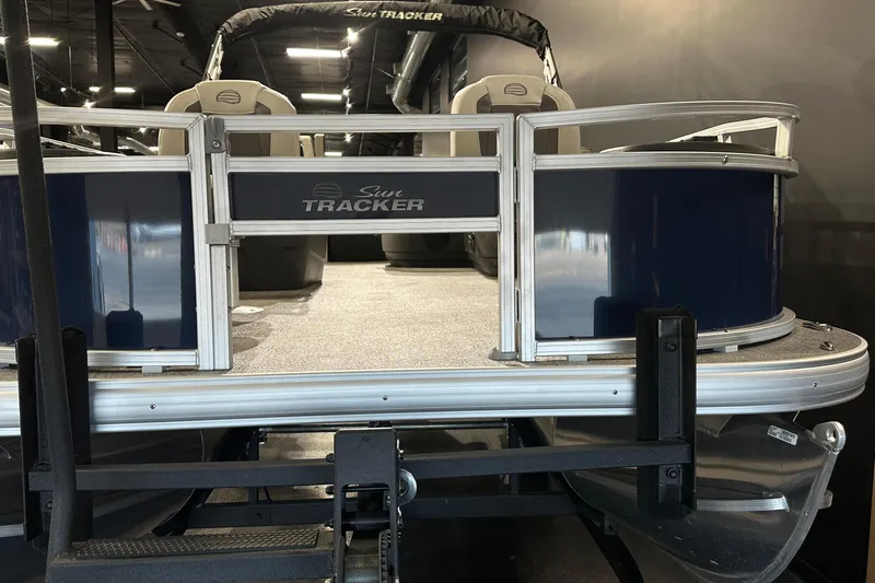 Slide: The Image of 2026 Sun Tracker Bass Buggy 18 DLX pontoon boat, blue and silver exterior, showroom display. - 21