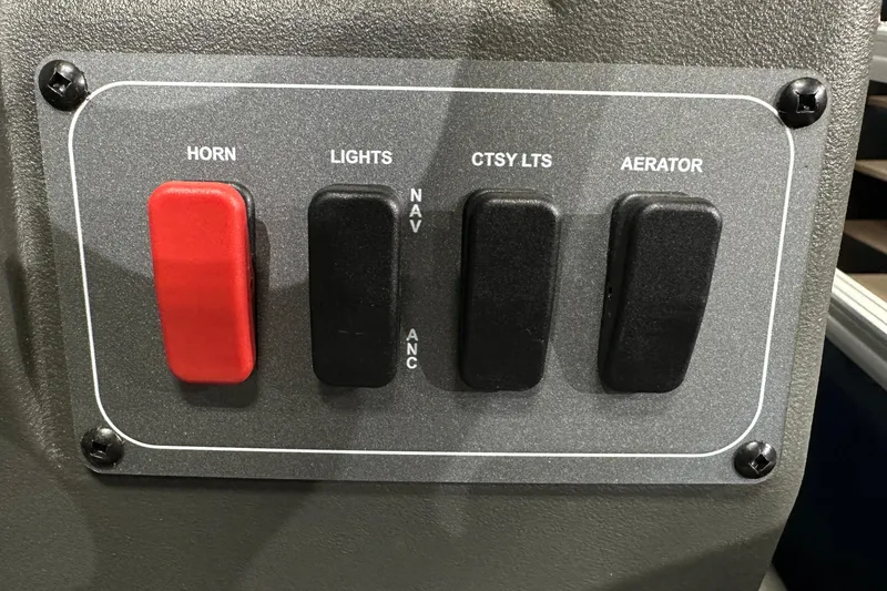 Slide: The Image of Control panel of 2026 Sun Tracker Bass Buggy 18 DLX with switches for horn, lights, and aerator. - 35
