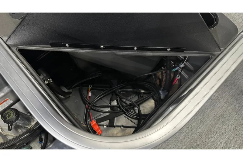 Slide: The Image of Storage compartment of 2026 Sun Tracker Bass Buggy 18 DLX with cables and components. - 41